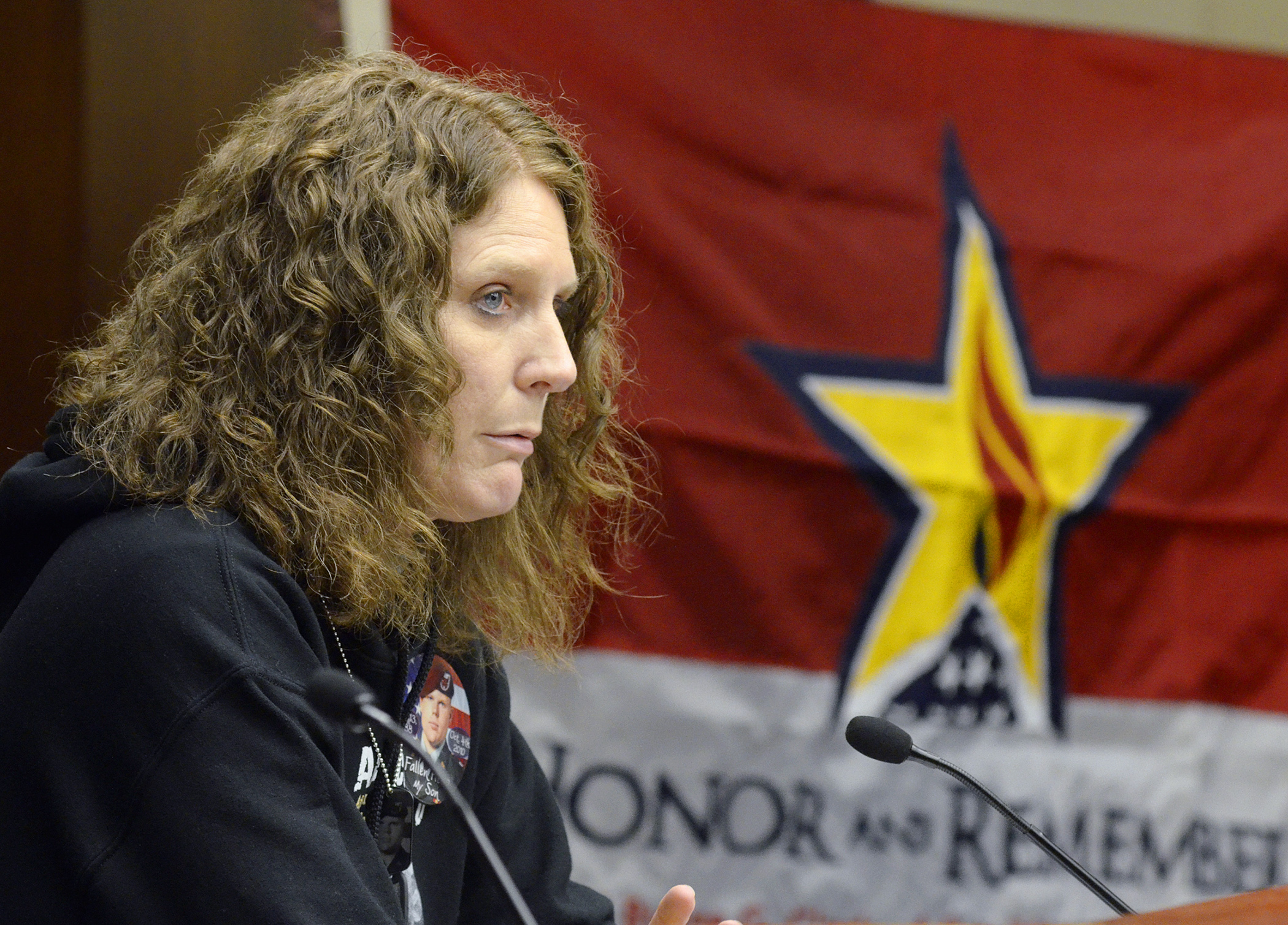 Tracy Clark, who lost her son, Ryane, in Afghanistan, testifies before the House Veterans Affairs Division Committee March 23 in support of a bill that would designate the Honor and Remember Flag (displayed in background) as an official symbol of the state’s commitment to military service members who have lost their lives in service to our country. Photo by Andrew VonBank
